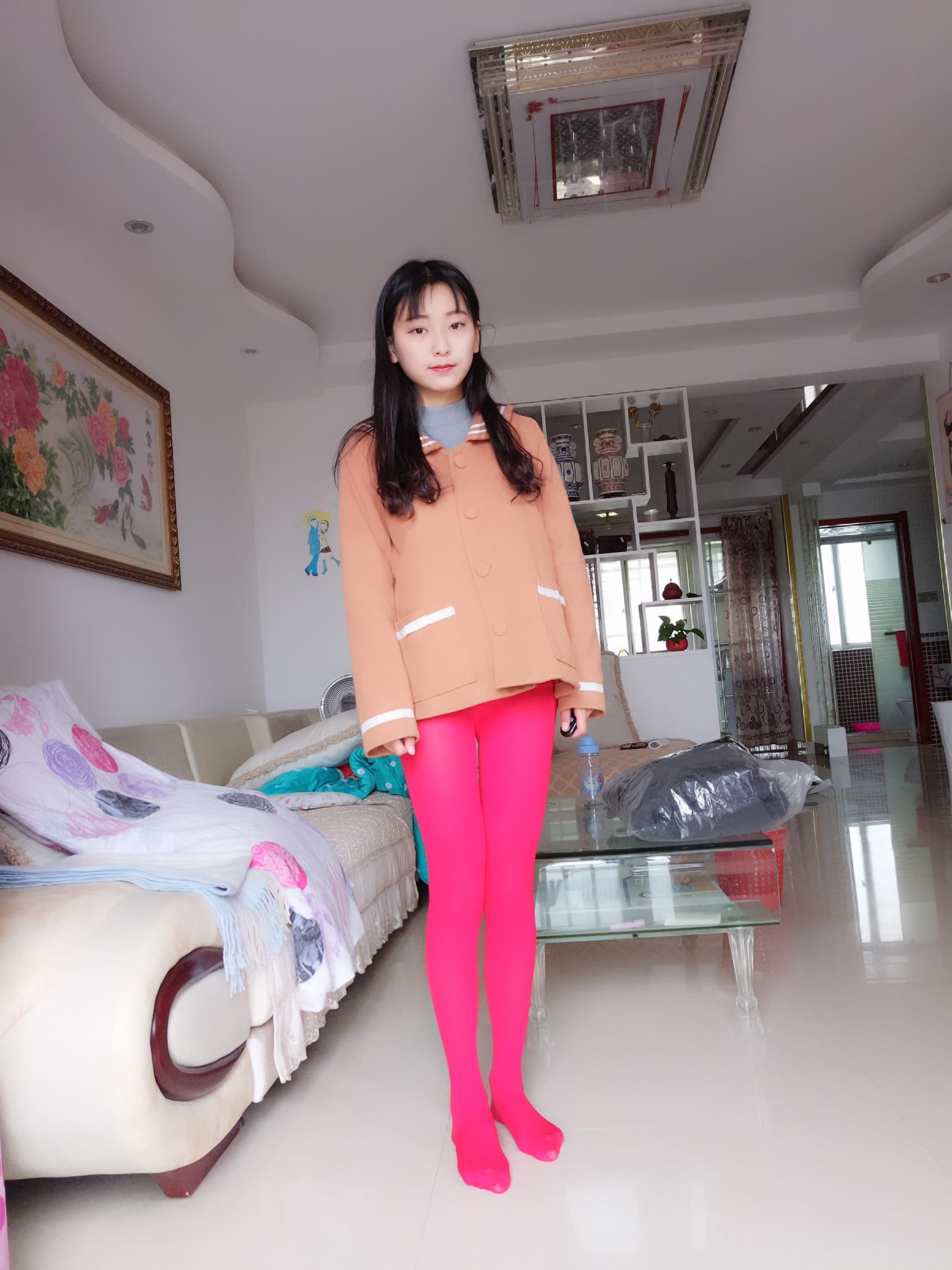 Home portrait of red tights contrasted with a brown knit top, toes peeking from the fabric, intimate vibe