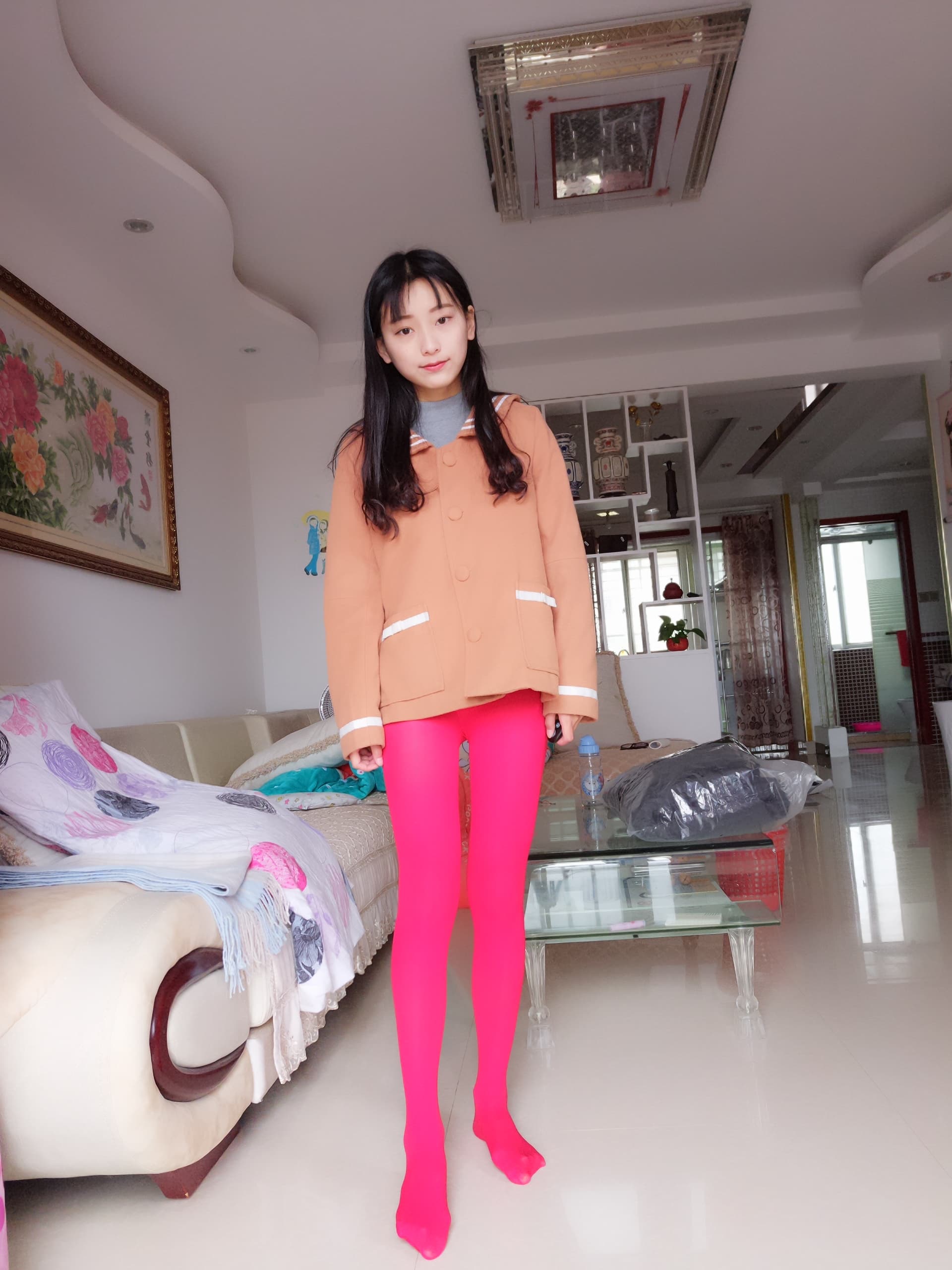 Detail shot of nylon-covered legs in bold red, bare heel visible, cozy interior backdrop