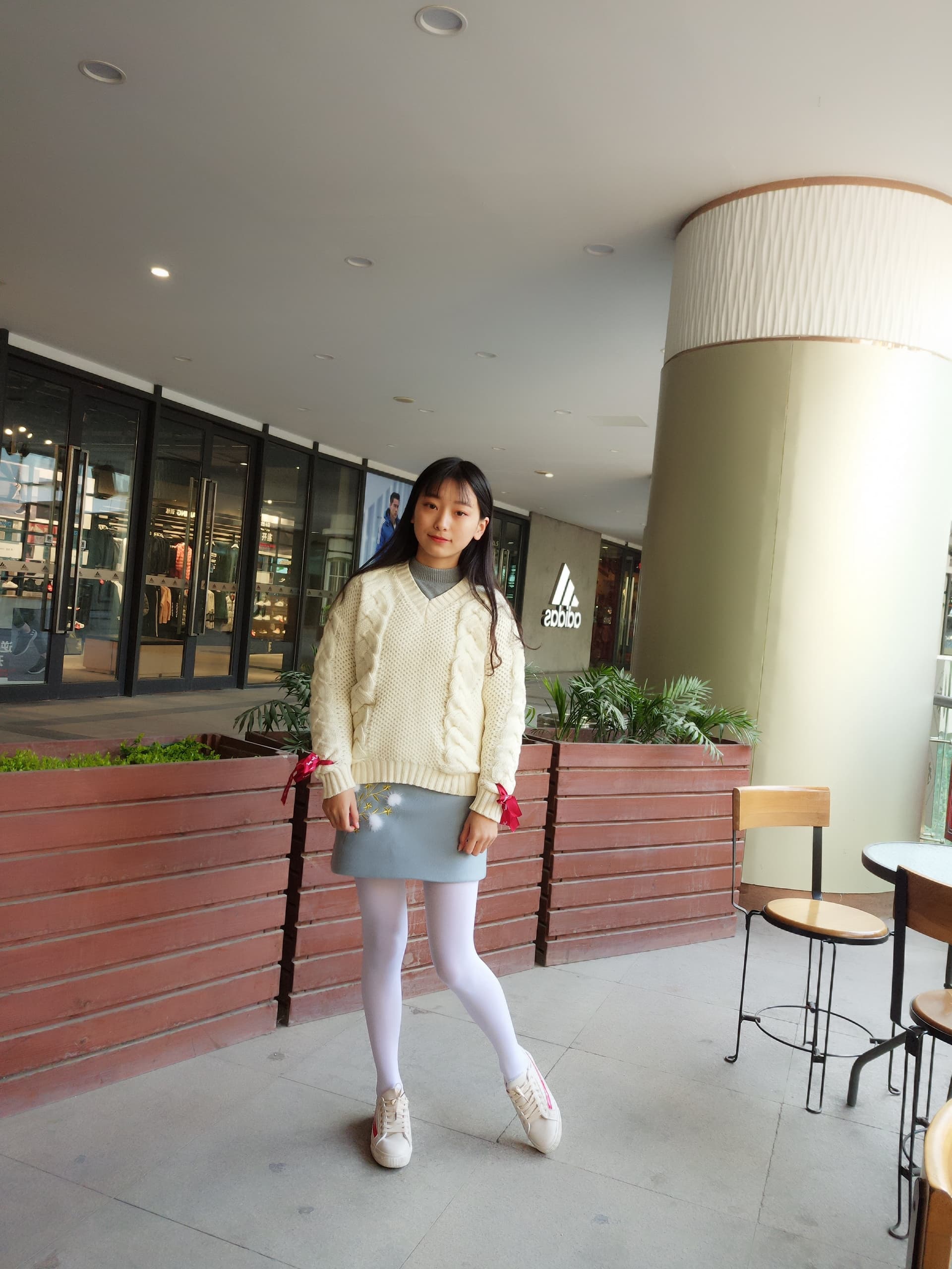 Pristine white opaque tights with barefoot peeking out beneath a short hem, neat composition