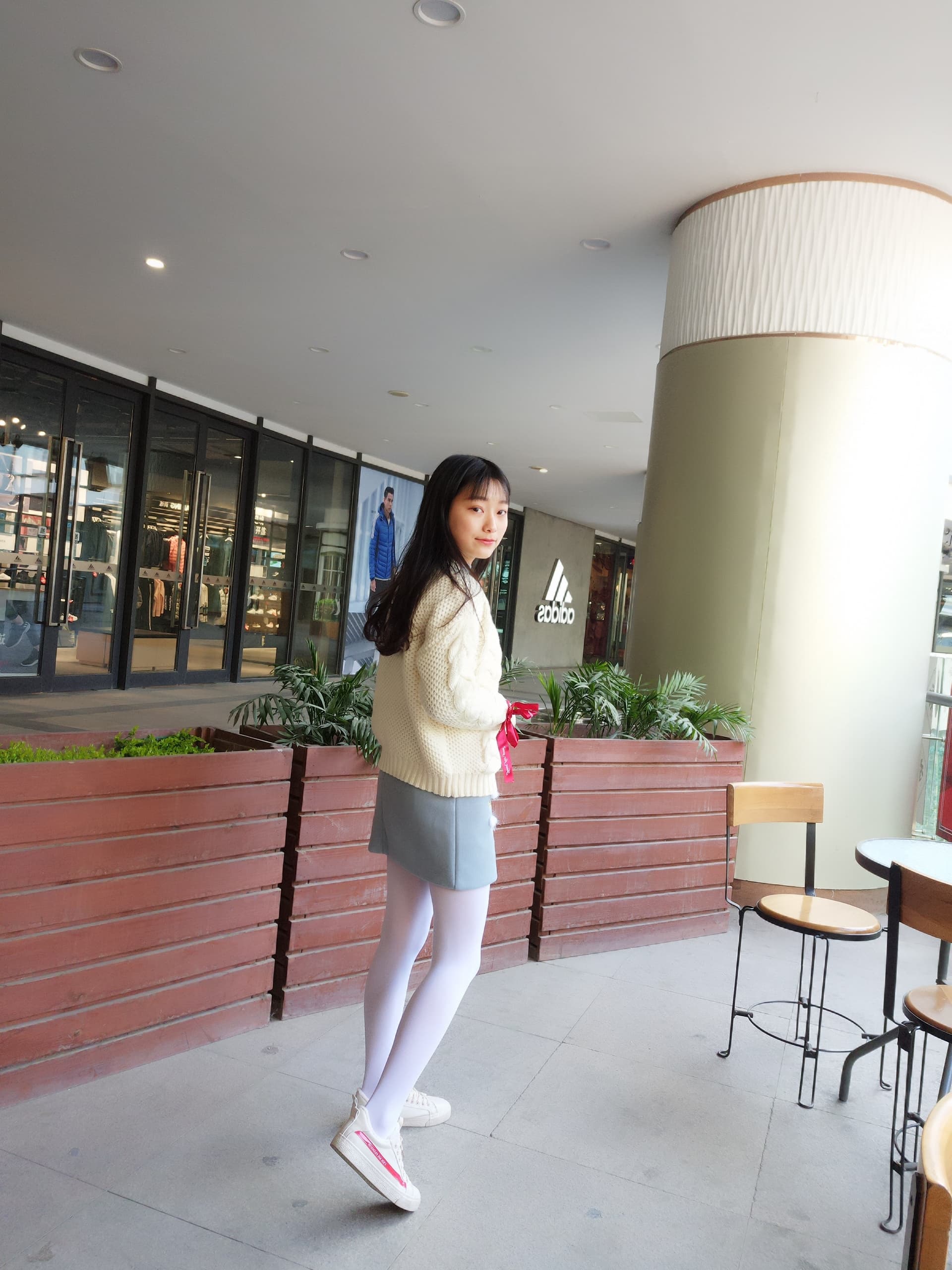 Softly lit image of white tights hugging legs, toes visible and relaxed on a textured surface