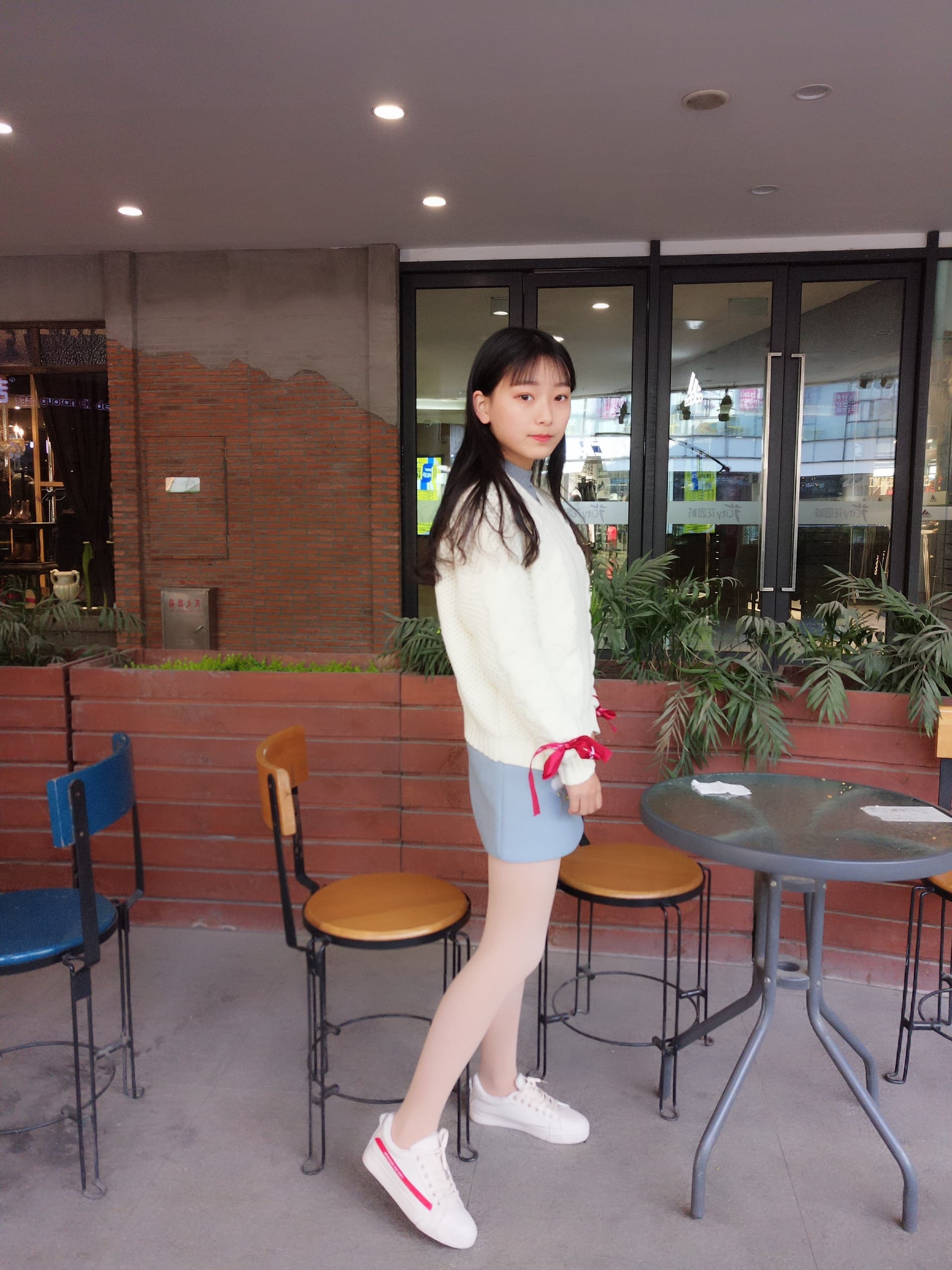 Legs wrapped in opaque nude stockings with bare feet resting provocatively on a plush surface