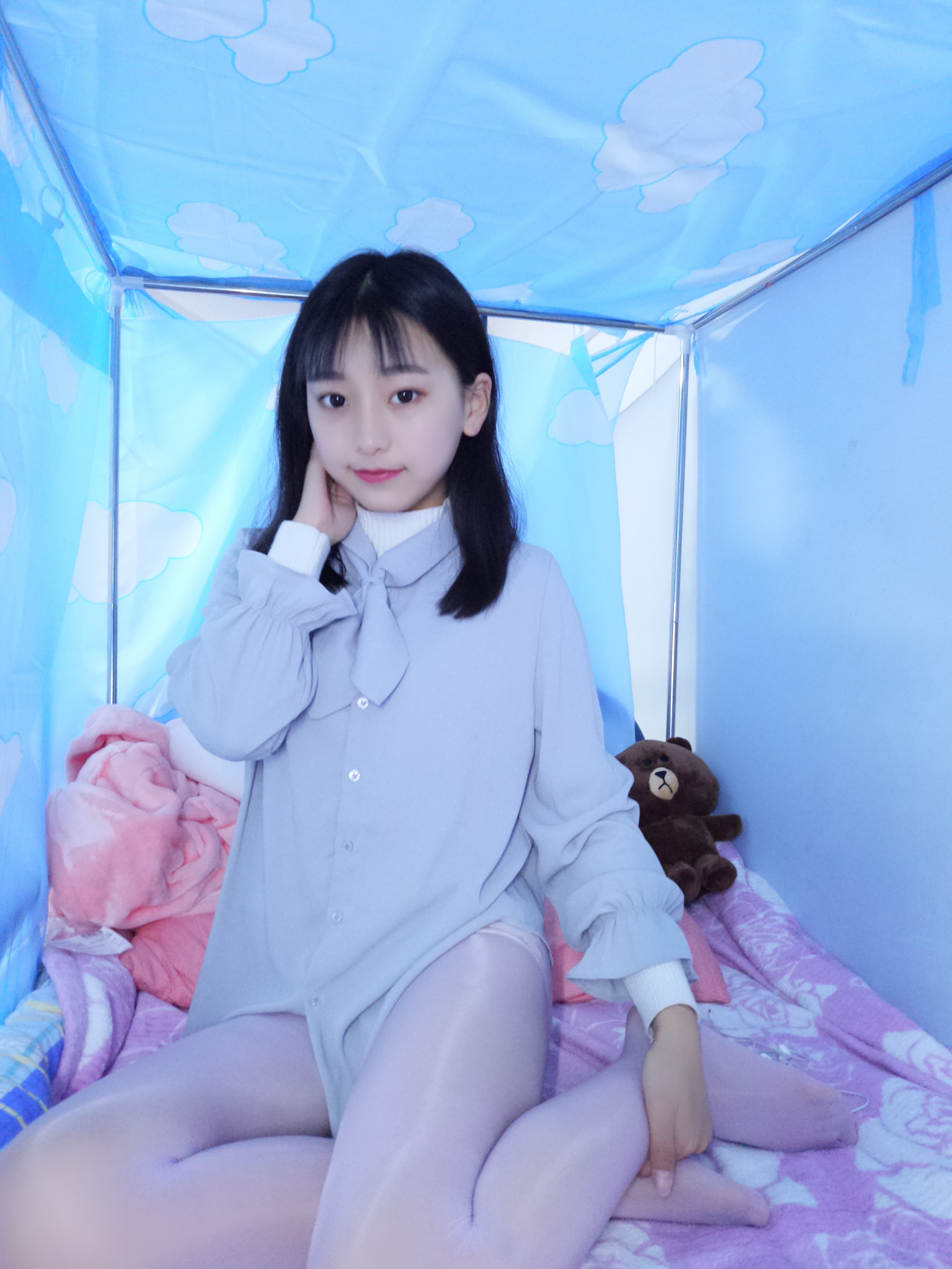 Gentle close-up of beige nylon stockings and white panties, toes peeking from sheer fabric on rumpled sheets.