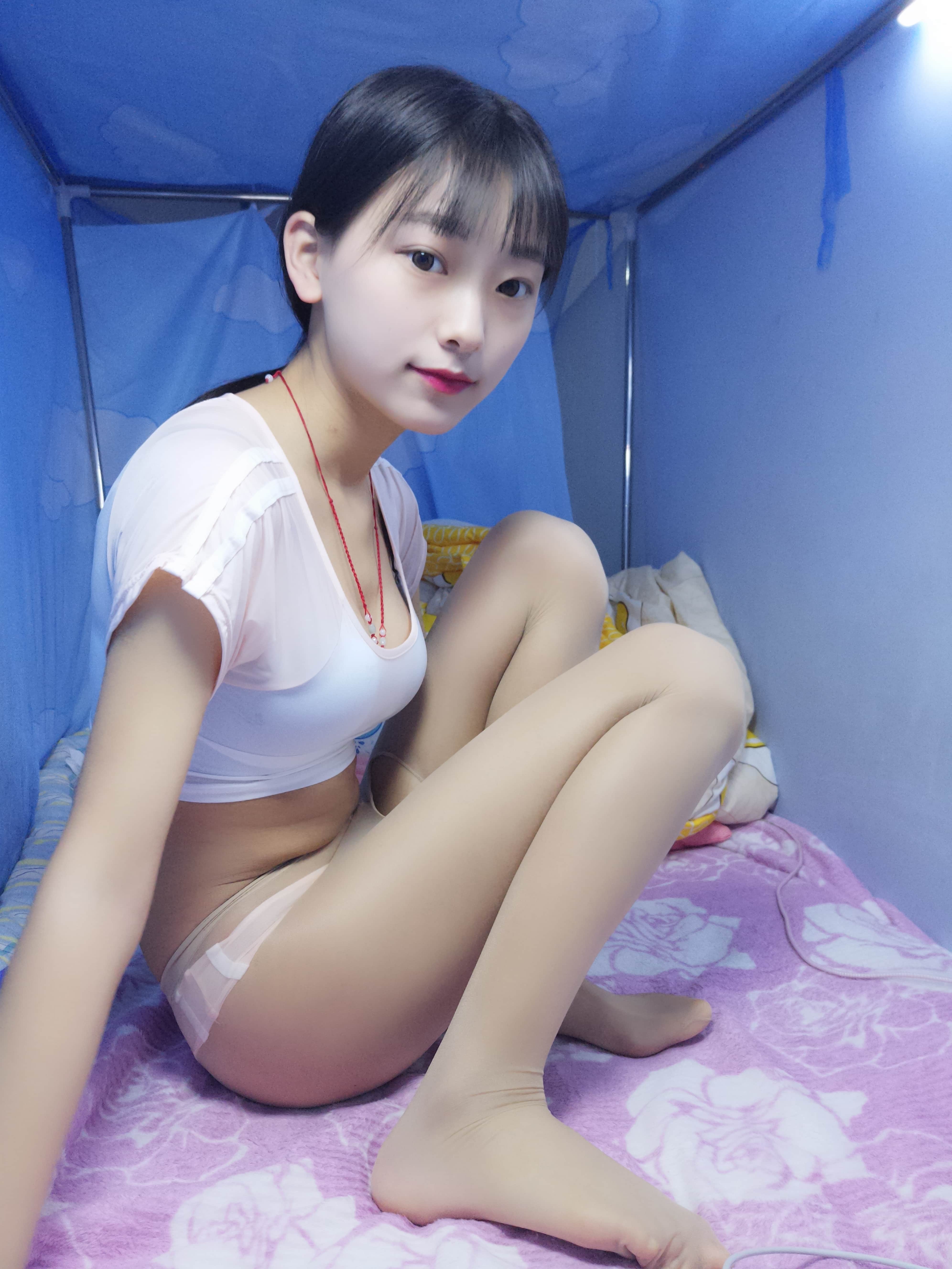 Close view of feet and stockings against bare skin, open-crotch detail just visible, emphasizing nylon stretch and toe contours.