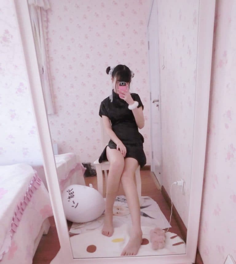 Close-up of feet with stockings half-pulled, toes flexing beneath soft lighting and a coy pose