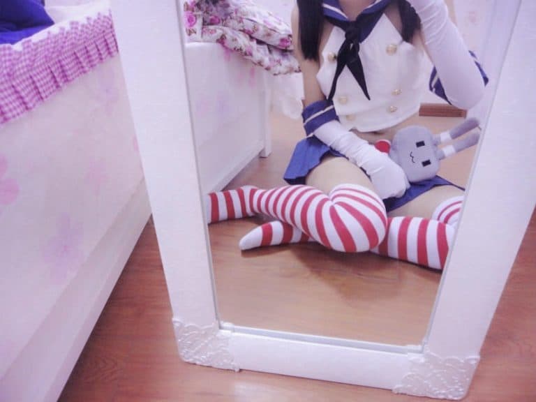 Close-up of exposed ankle and toes beside glossy stocking seam, costume ribbons softly framing the scene