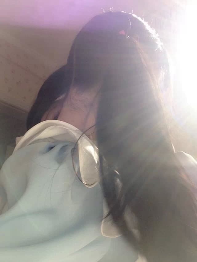 Adult maid in classic uniform kneels, glossy stockings half-slid, bare foot arch visible against hardwood floor