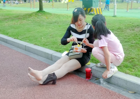Drying Her Bare Feet by the Road