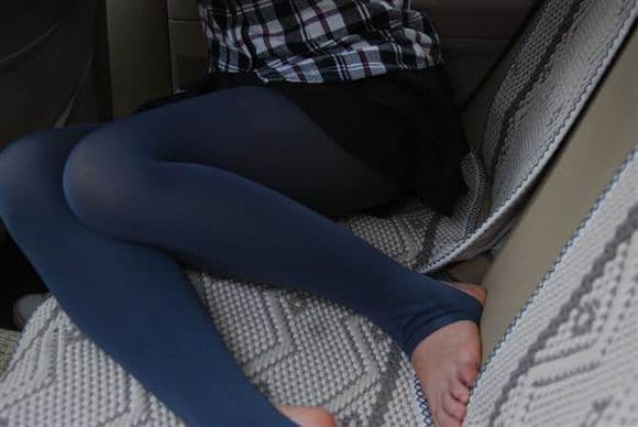 Hand peeling a cotton sock off an adult foot, toes emerging slowly from soft knit fabric