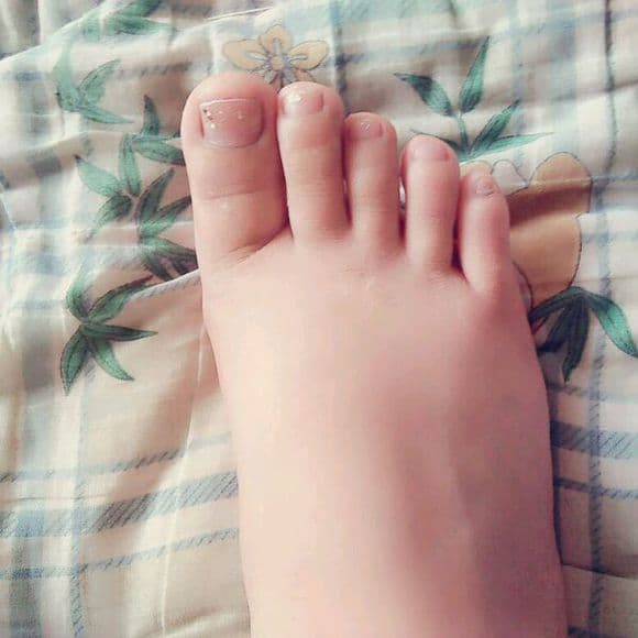 Playful mid-air shot of bare small feet kicking, toes spread and soles animated in motion