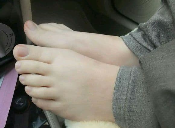 Cropped study of bare arches and toes, nylon sheen on stockinet and soft shadowing on the sole