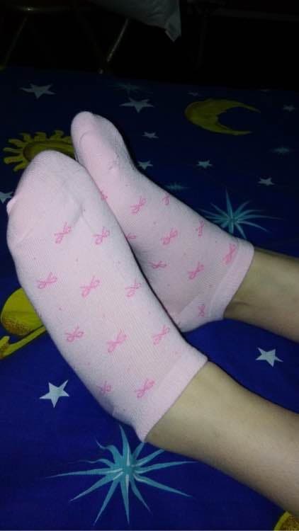 Pink boat socks with heart patterns hugging feet, pastel tones and soft cotton texture visible.