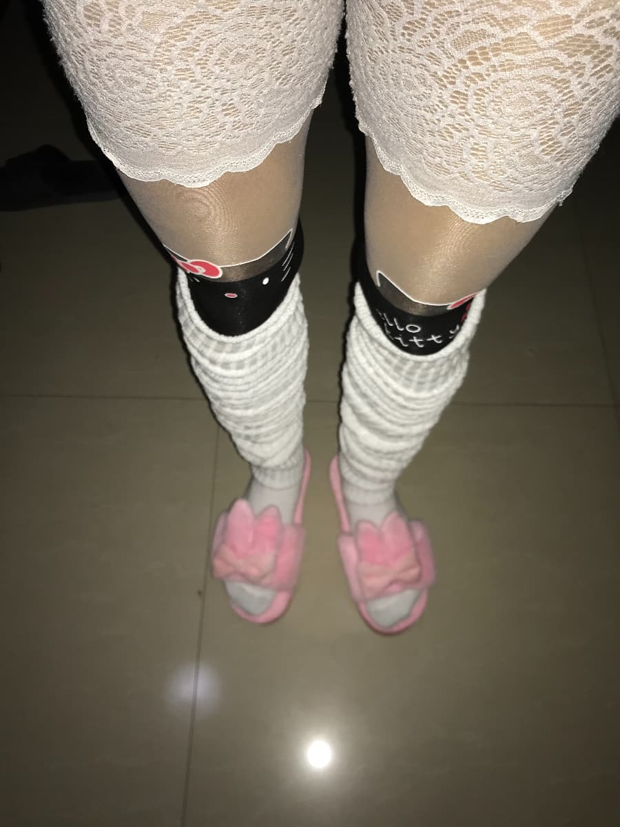 Leg extended on plush surface, silk stockings smoothed over calf with subtle creases and delicate toe outline