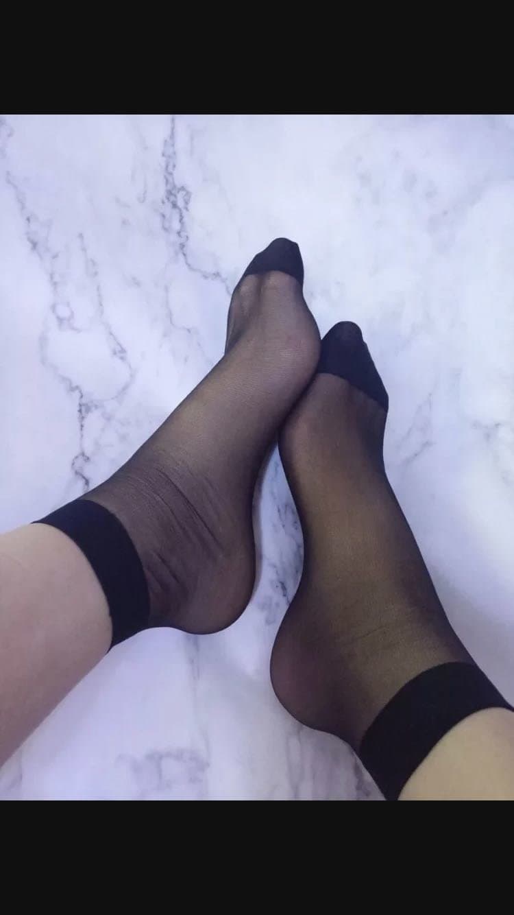 Black thigh-highs hugging smooth calves with glossy sheen and subtle toe peek