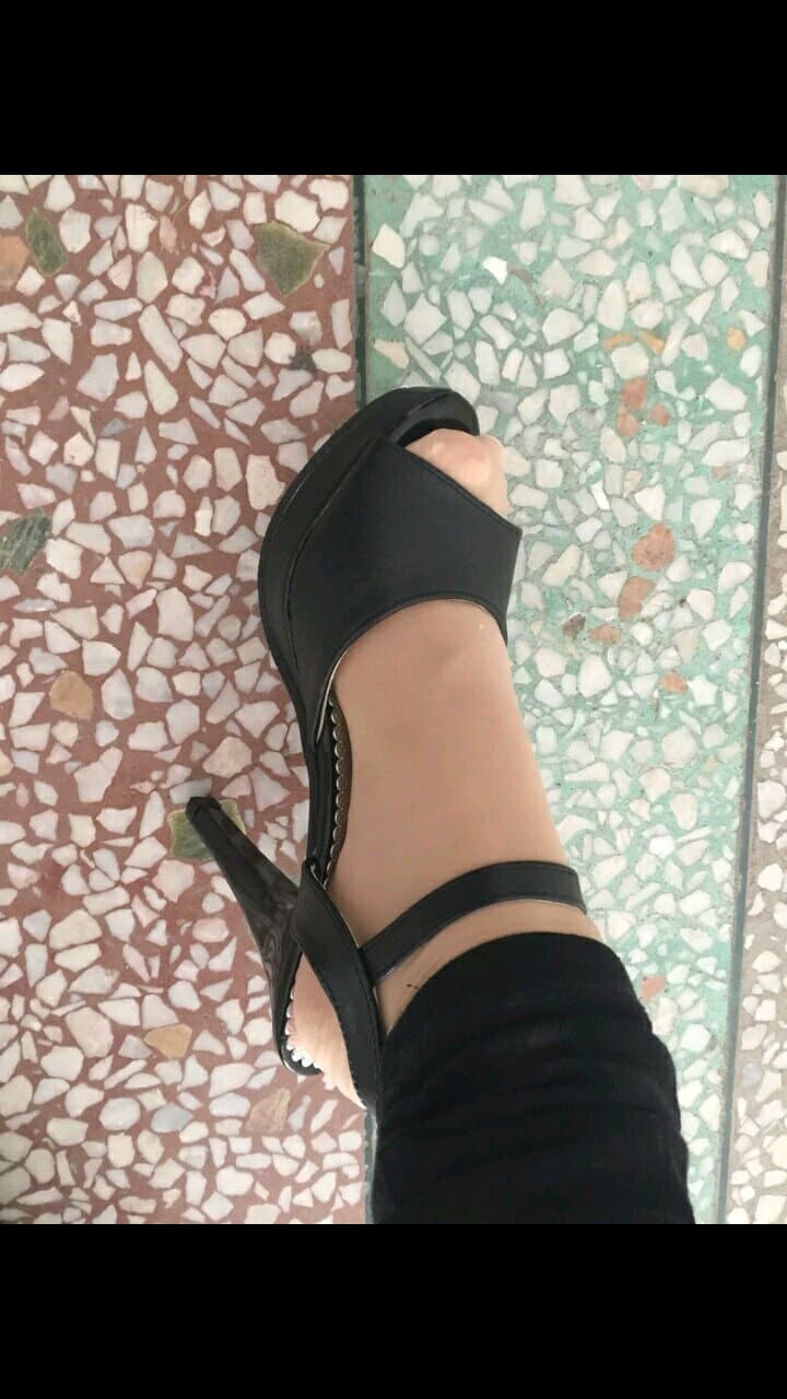 Stylish close-up of high heel on foot clad in short stocking, arch elevated and stocking sheen catching light