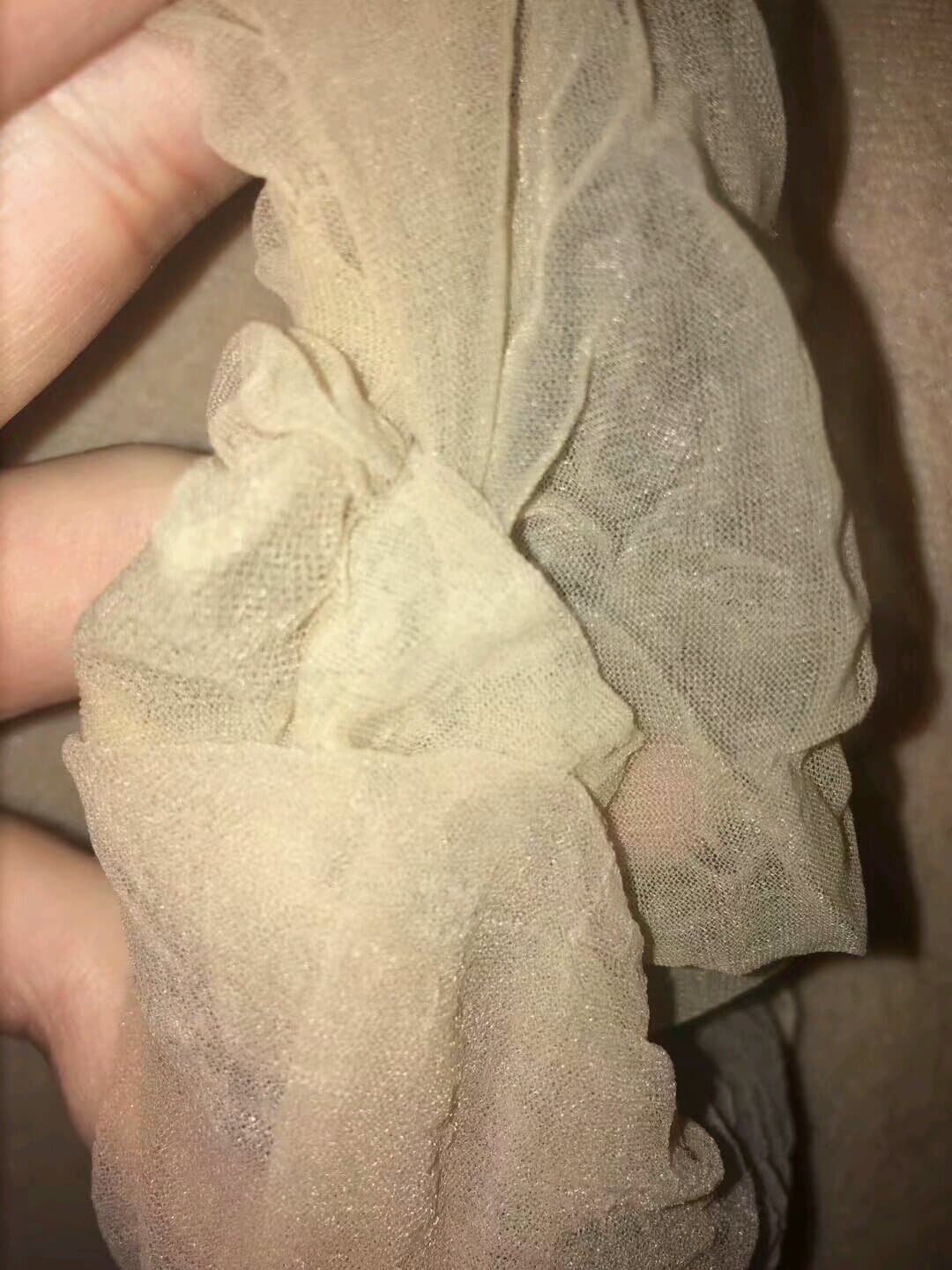 Close-up of nylon-clad toes curled slightly, stocking texture visible as a fingertip hovers nearby, soft skin beneath