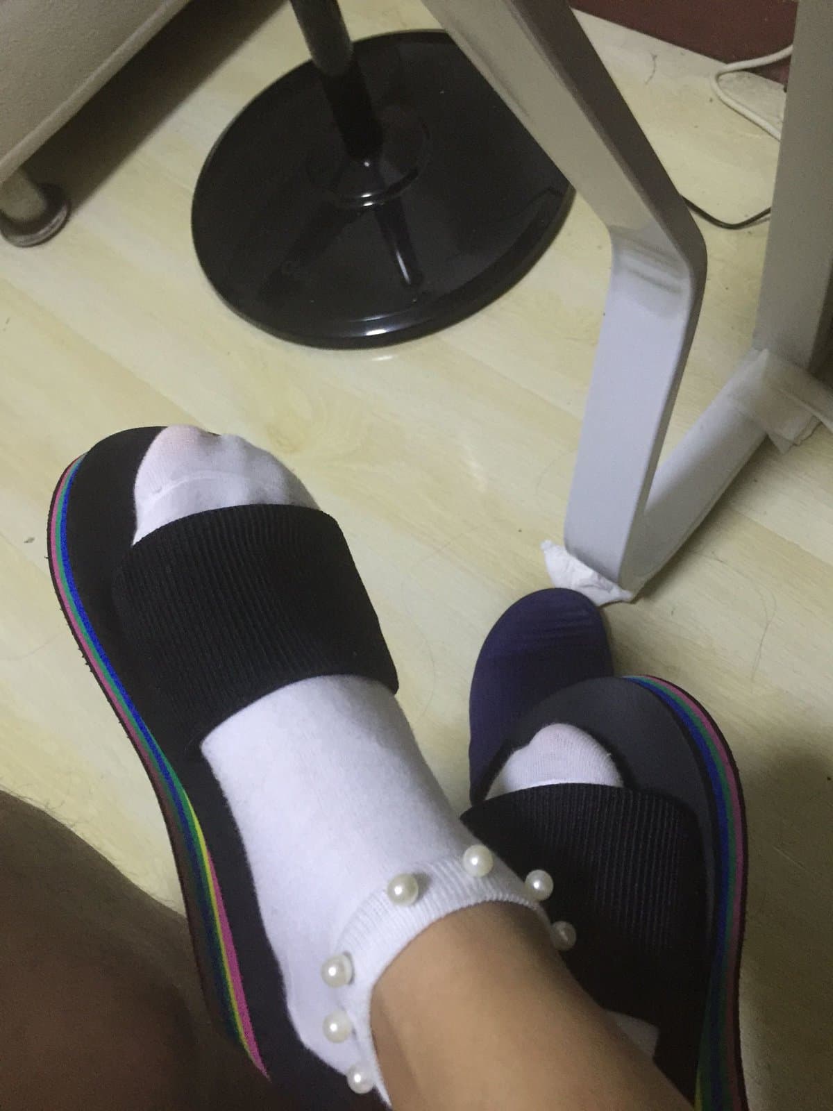 Natural candid shot of bare feet with rolled cotton socks nearby, toes relaxed and skin showing warm natural tones