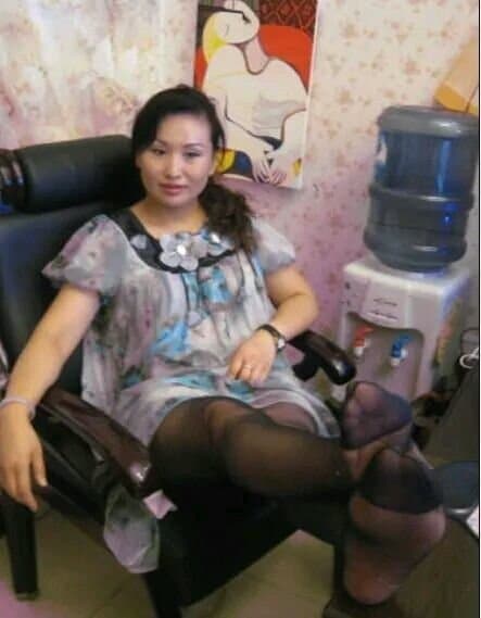 Elegant mature feet in sheer silk stockings, arch emphasized and toes gently pressing through the fabric in soft light