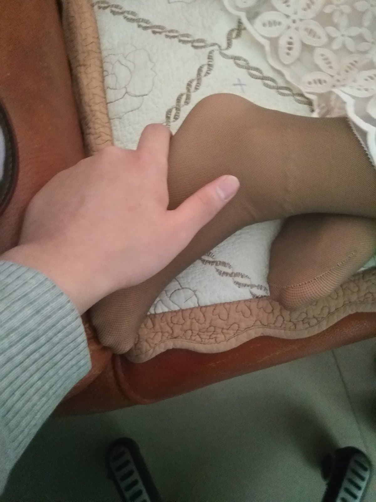 Elegant close-up of mature foot in silk stockings, arch emphasized and nylon sheen reflecting soft studio light attractively.