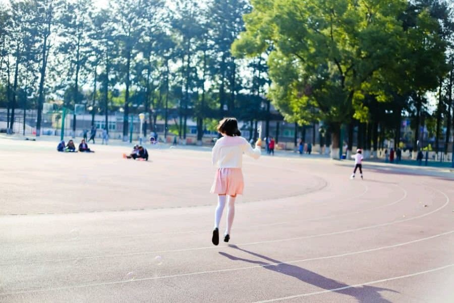 Confident model crossing legs, revealing glossy stocking seam and arch of foot against chair upholstery