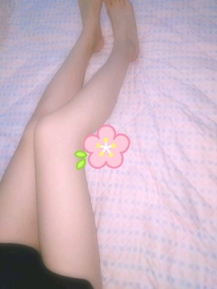 Newcomer posing on couch with one bare foot exposed and nylon stocking rolled down to ankle