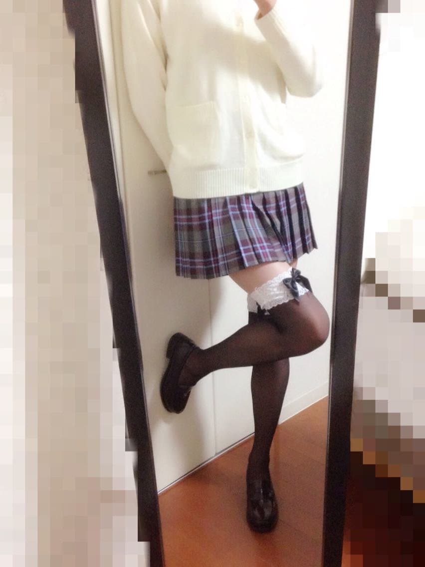 Newcomer poses on a chaise, bare feet crossed and toes pointed, a sheer stocking rolled down around one ankle in soft studio light.