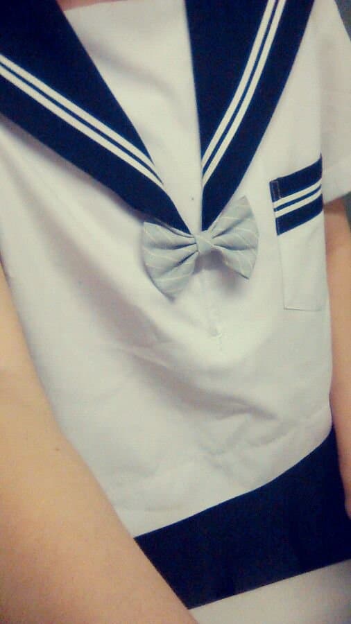 Ruohua models a sharp suit jacket with a grey butterfly skirt, legs crossed to showcase sheer stockings and a peek of bare toes.