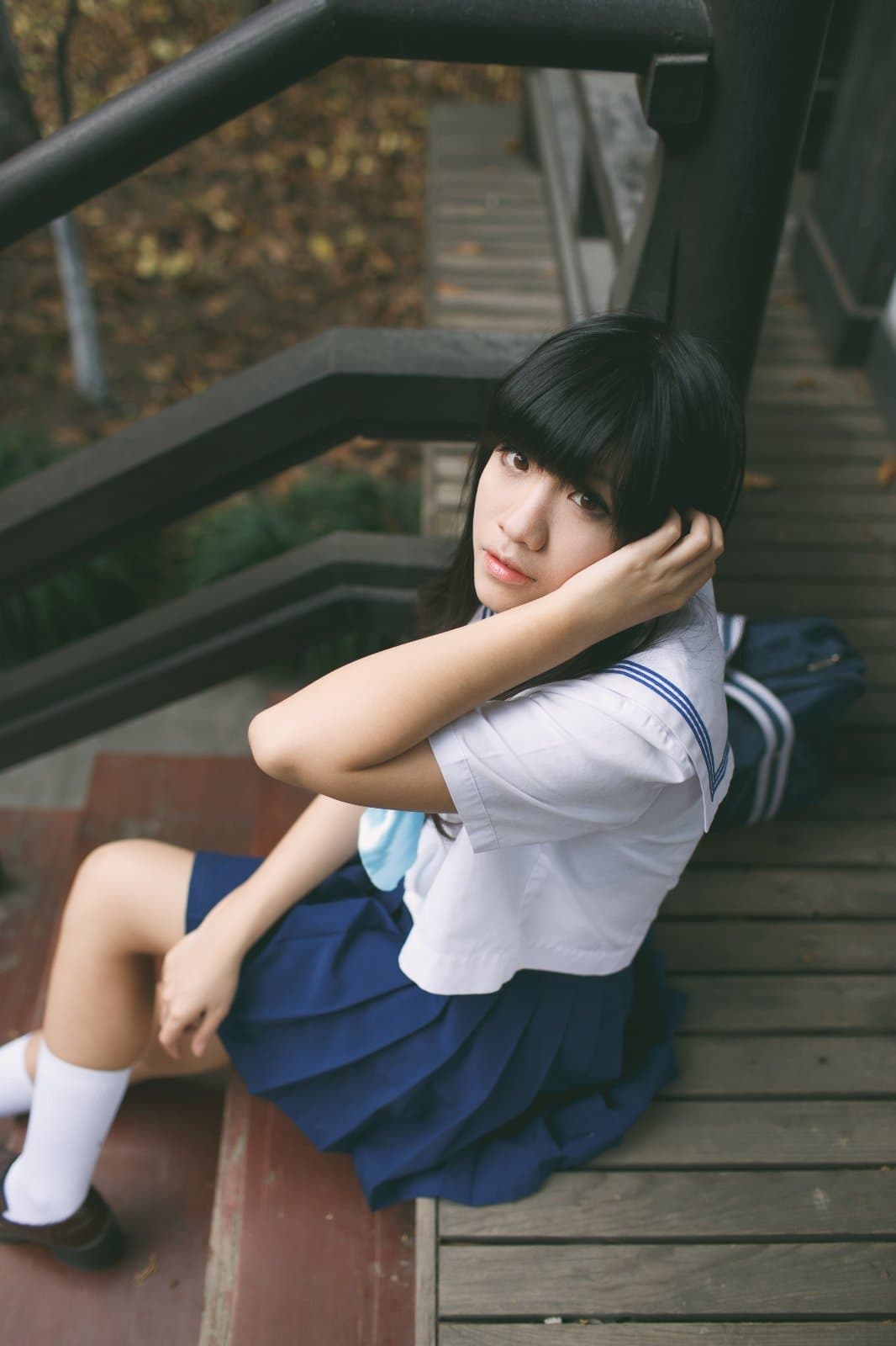 Model posing in a minimalist Shanghai studio, ankle-length socks and sheer stockings styled with a fresh, Japanese-influenced outfit and soft lighting