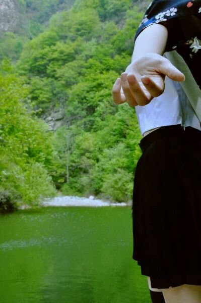Young woman’s bare feet on green grass, toes spread, cotton socks nearby, sunlight highlighting soft arches and relaxed posture