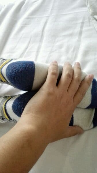 Close shot of a slender man's foot in snug cotton socks, fabric hugging the heel and toe contours.