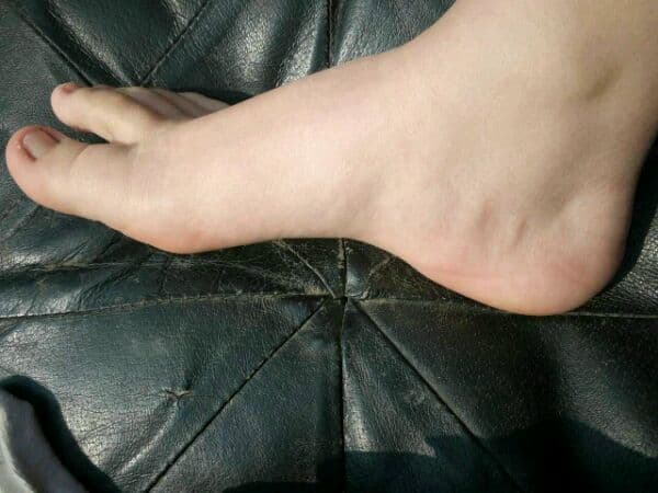 Gentle shot of a young woman's feet in soft cotton ankle socks, toes slightly curled and lighting warm.