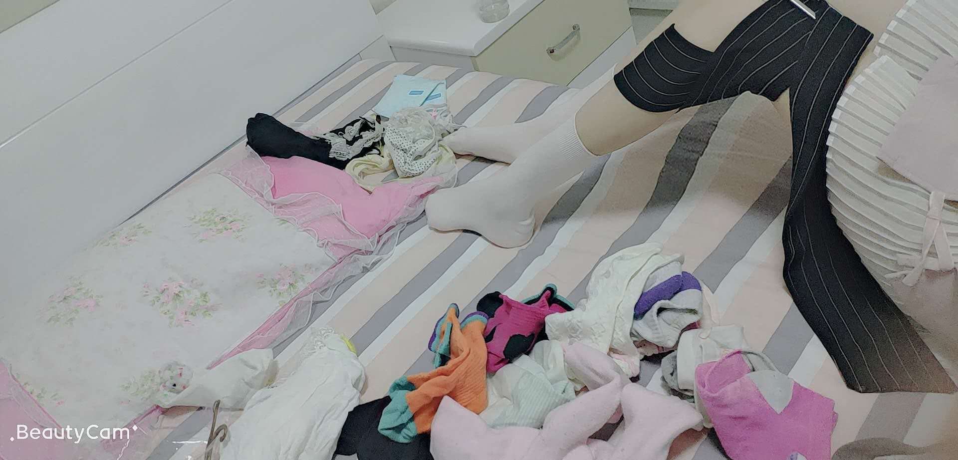 Overhead shot of her feet in slightly rumpled cotton socks on a couch, legs relaxed and inviting.