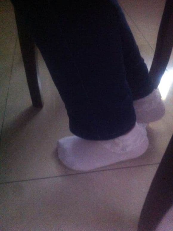 Pair of feet wearing lace-trimmed white cotton socks, toes relaxed and fabric hugging arches softly