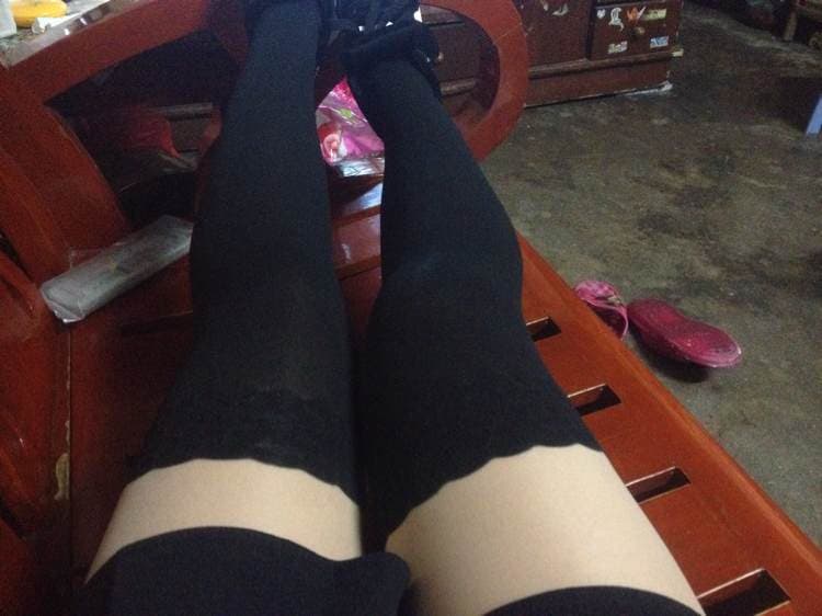Long over-the-knee socks hugging flushed calves, toes pointed and ankle highlighted