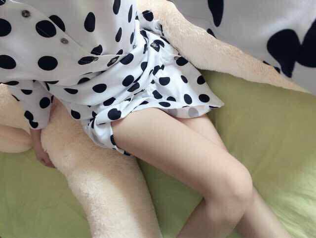 Playful adult holding candy near a pocket with stockinged legs and a bare toe flirting at the edge of fabric.