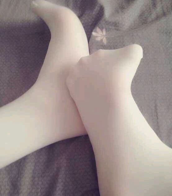 Plush feet in sheer stockings, full soles and rounded toes, intimate close-up with soft lighting