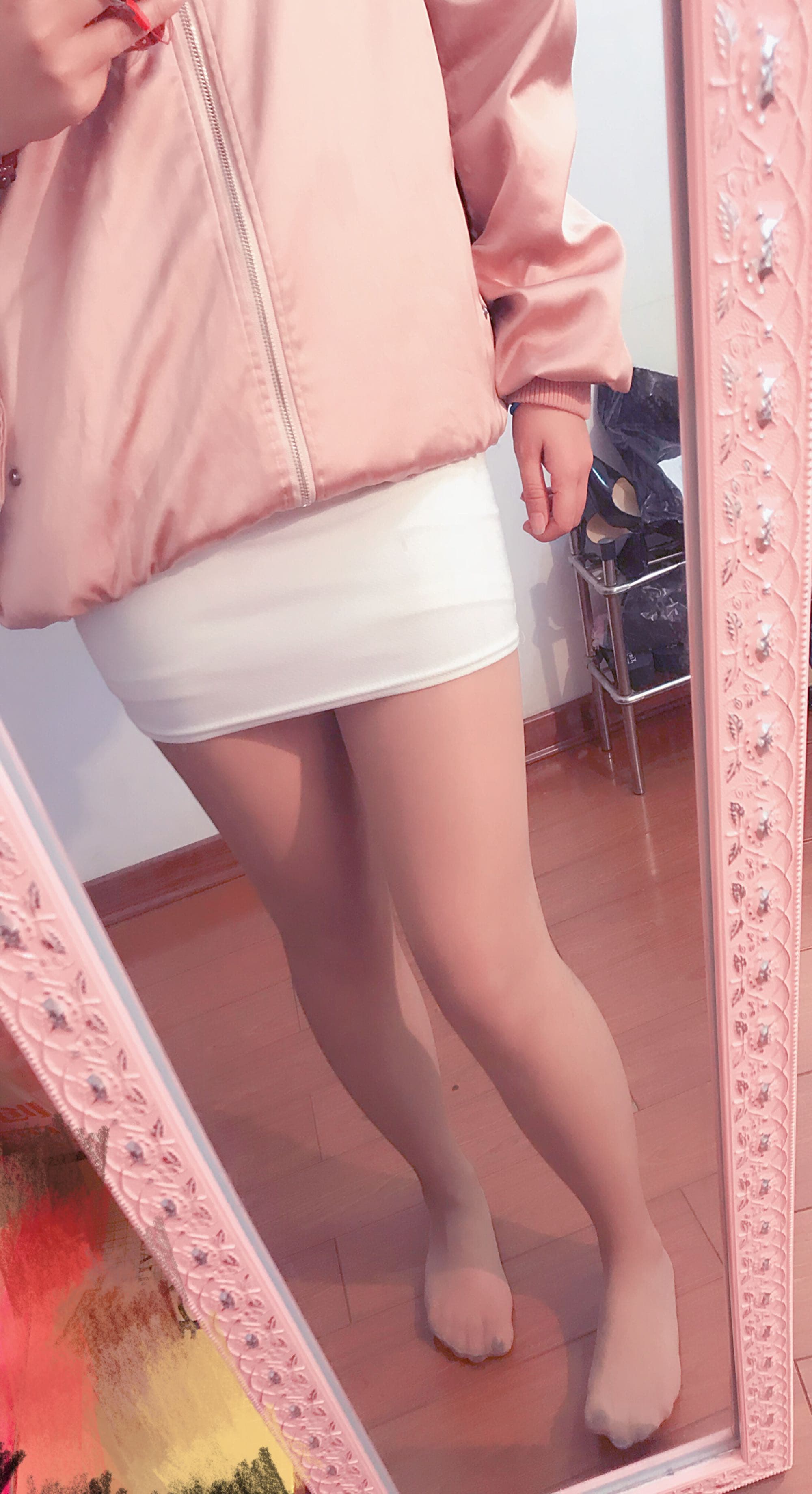 Portrait of Yiya reclining, stockings glinting softly as her feet extend toward the lens, serene expression visible