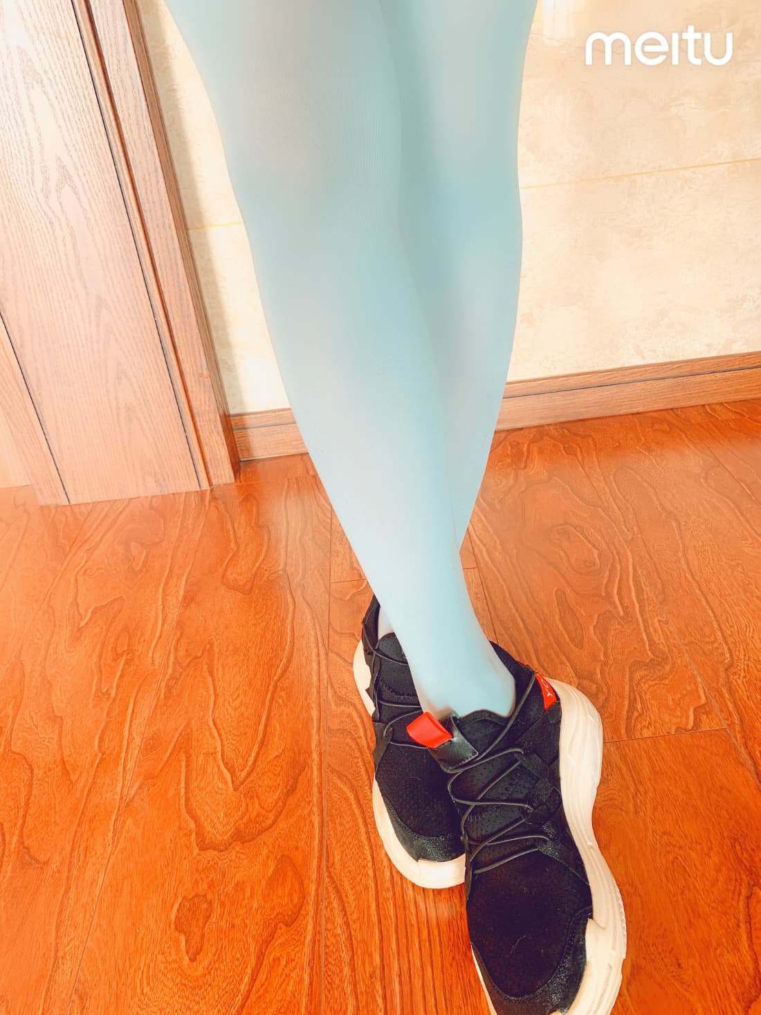 Single evocative photo of a sock-clad foot with a peek of bare heel and soft, warm lighting