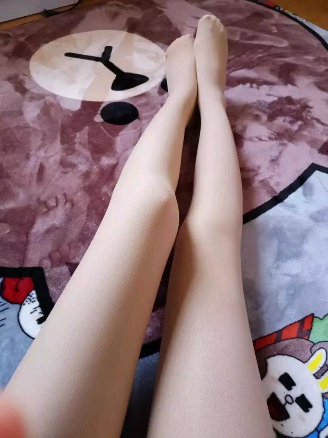 Low-lit close-up of nylon-covered toes and exposed heel with soft shadows and intimate texture