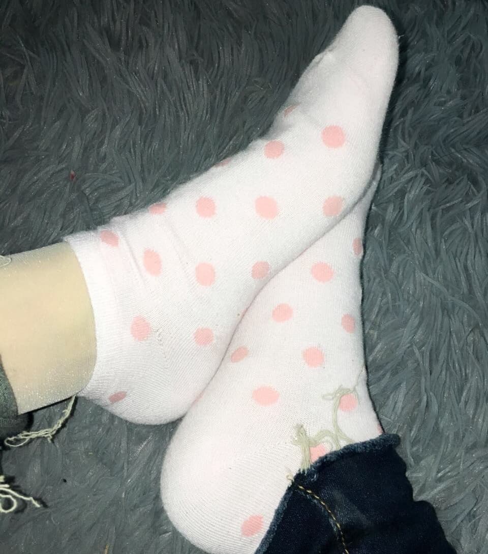 Close-up of silk stockings peeking from beneath cozy cotton socks, showing layered textures and ankle detail