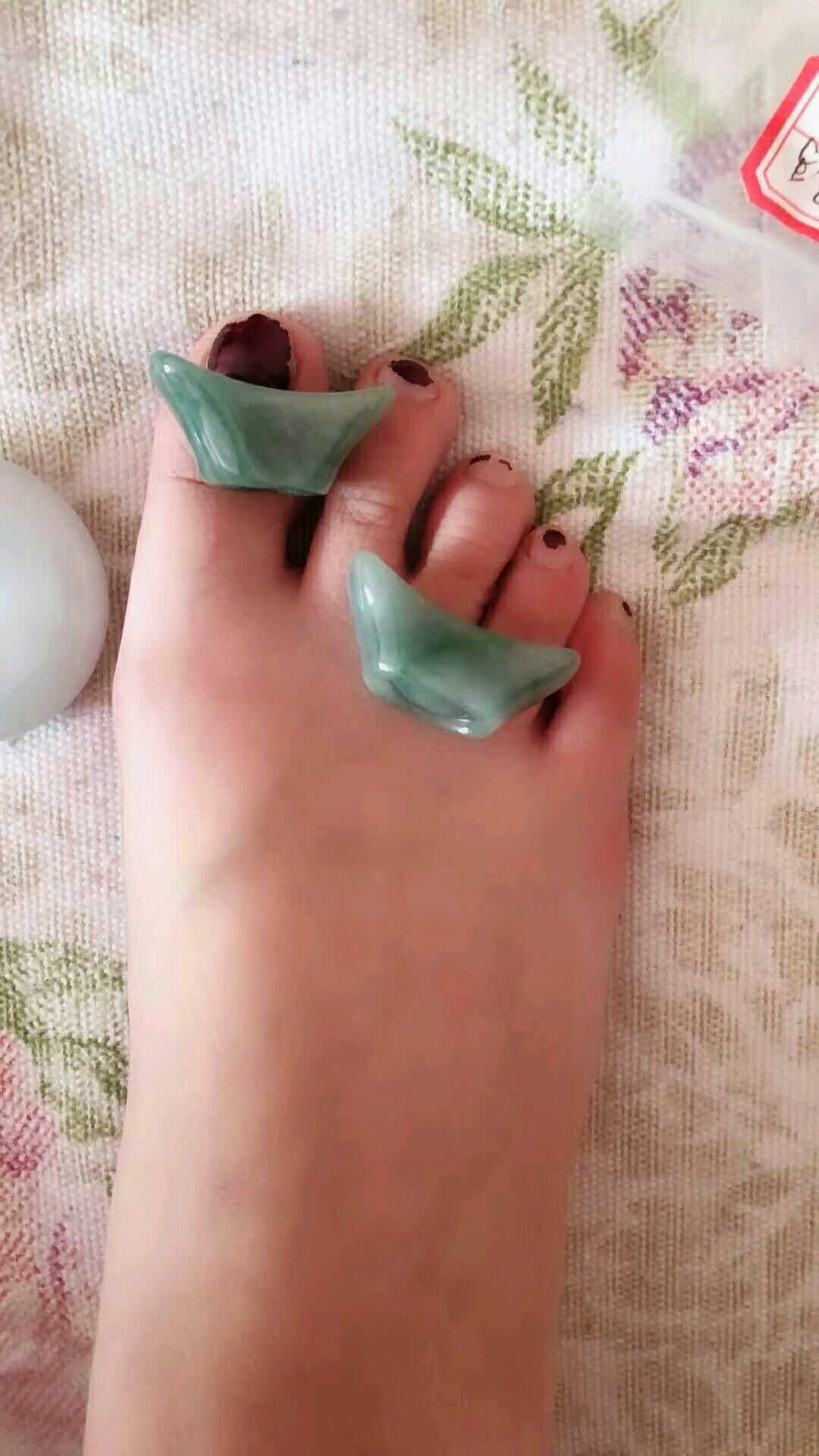 Delicate Asian foot posed on a jade satin pillow, sheer stocking highlighting the arch and ankle