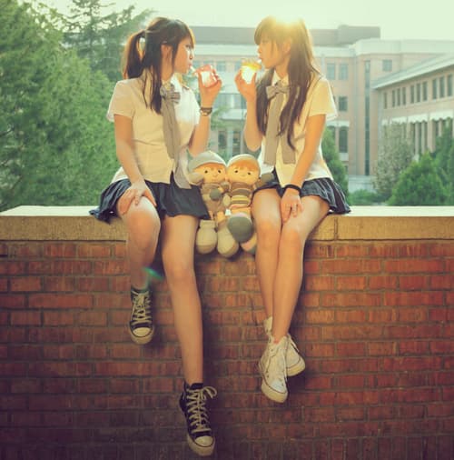 Close-up of a hand sliding a cotton sock off a bare foot, revealing the arch and toes against soft bedding.