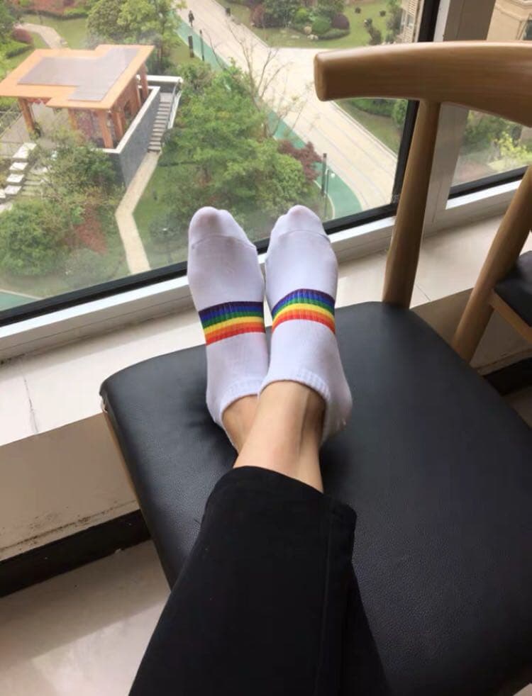 She models new strappy heels with exposed toes, nylon stockings peeking above delicate shoe straps.