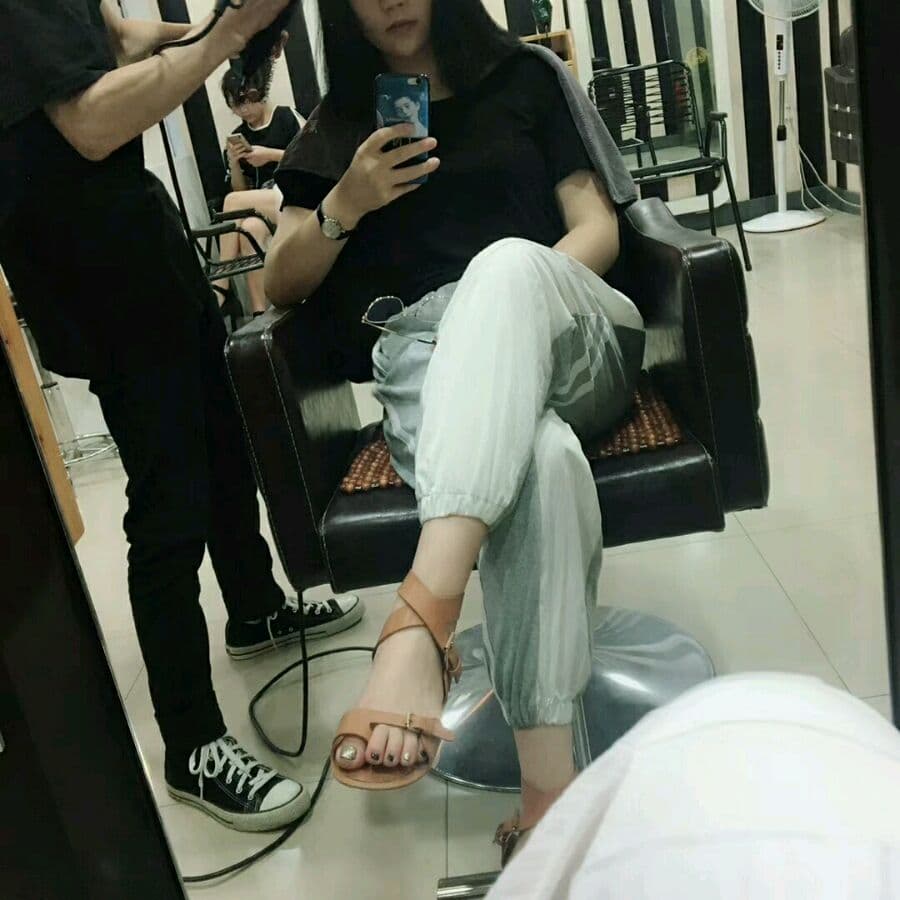 Portrait of graceful Asian feet in partially removed nylon, soft sock textures visible beside heels