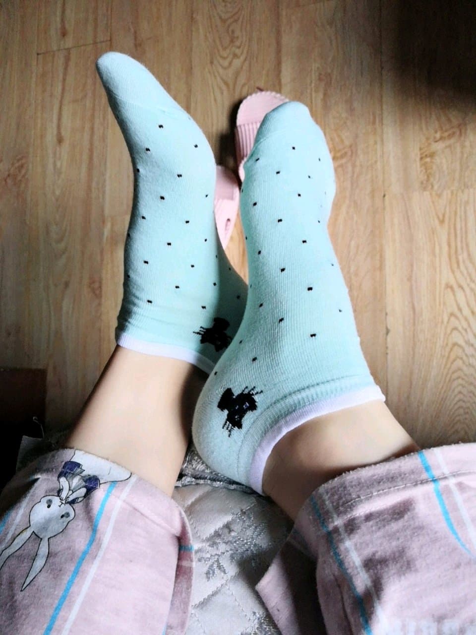 Sunlit bare feet with nylons pooled at ankles, soft cotton socks folded nearby in morning light