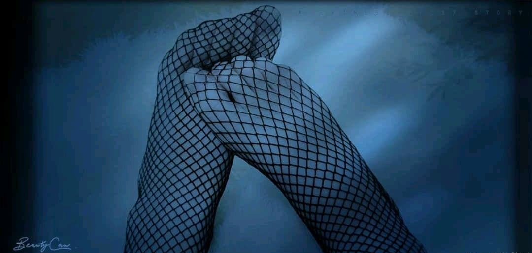 A pile of worn cotton socks beside a sofa, one pair partially rolled down and revealing a bare ankle.