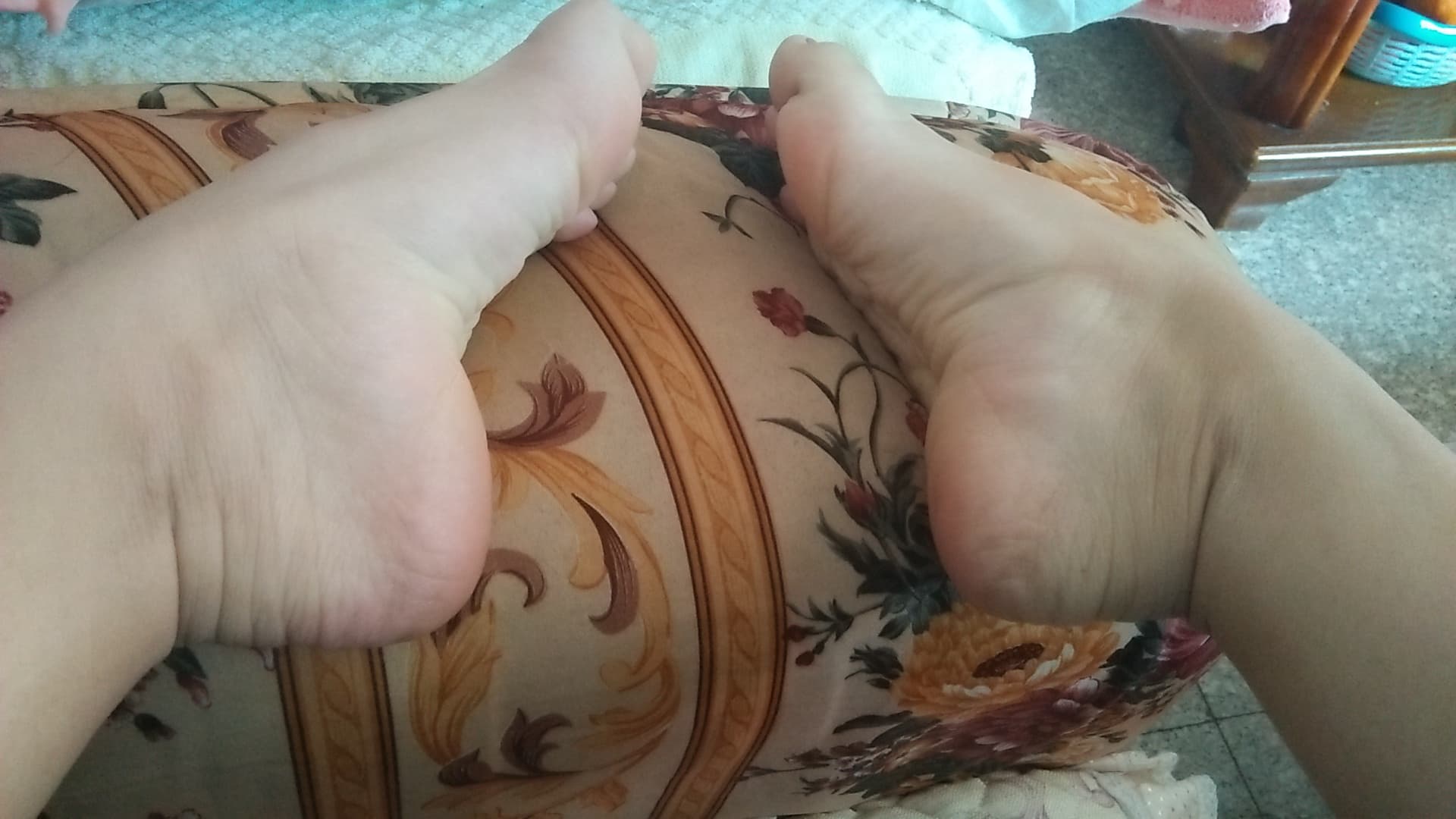 Adult dancer demonstrating pointed toes and arched feet in ballet-inspired pose, sheer nylon accentuating muscle and contour under studio lights.