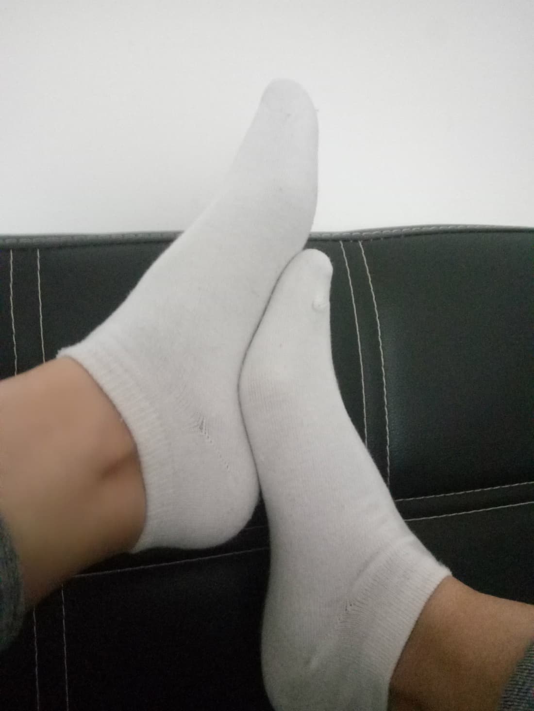 Feet in slightly damp socks showing darkened fabric and clinging texture after walking