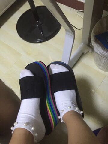 Casual portrait of girlfriend’s feet in slightly worn cotton socks and exposed ankle