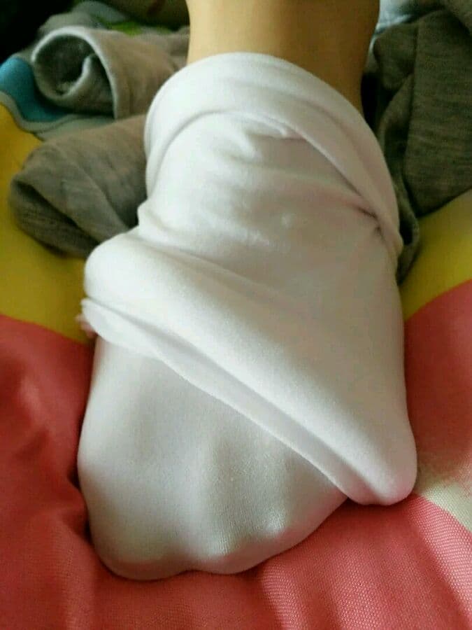 Pair of short silk stockings draped over feet, toes visible through thin nylon with subtle ankle imprints.