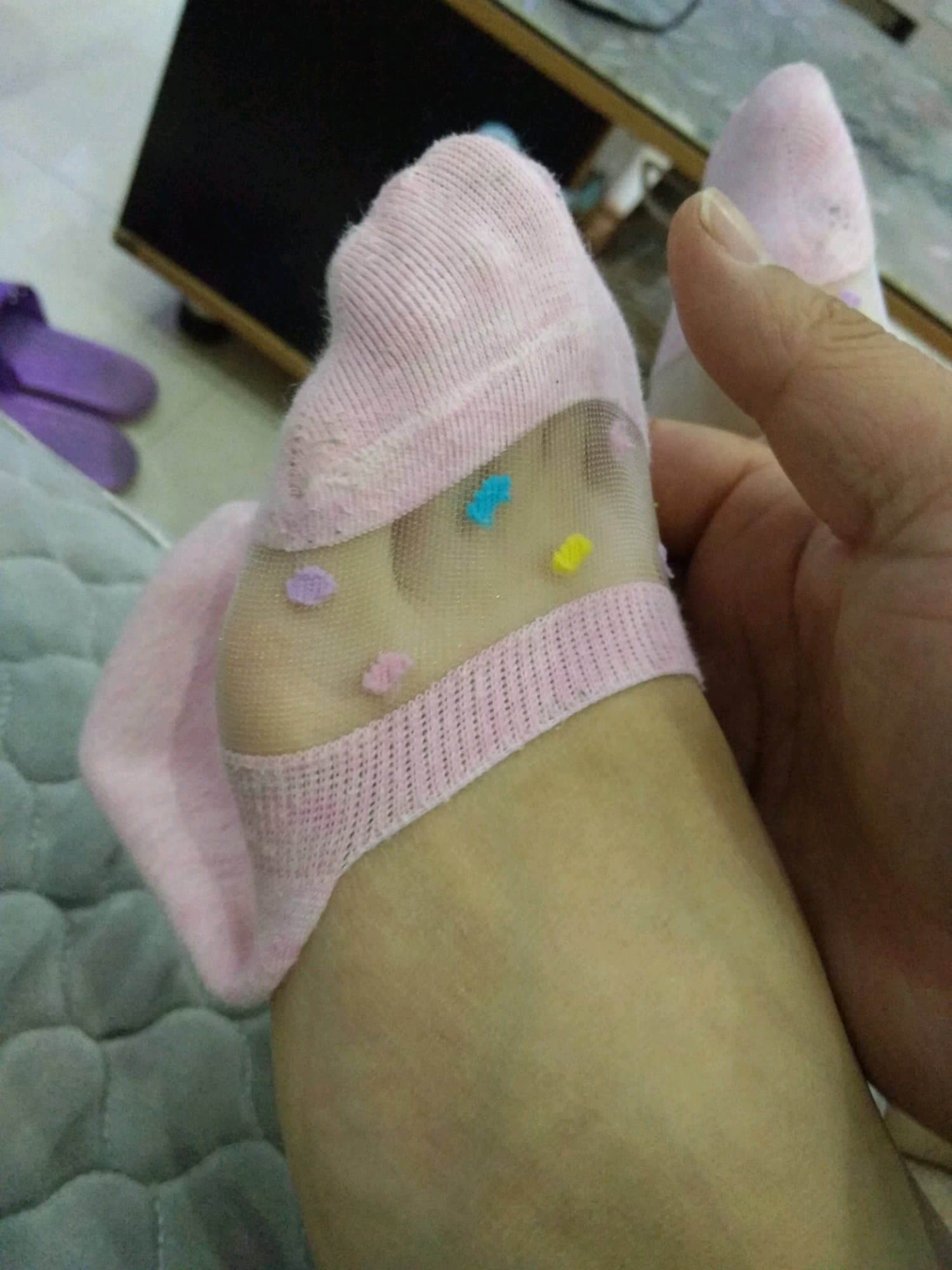 Delicate feet posed near a glass edge, light refracting through the pane onto stockings and bare skin